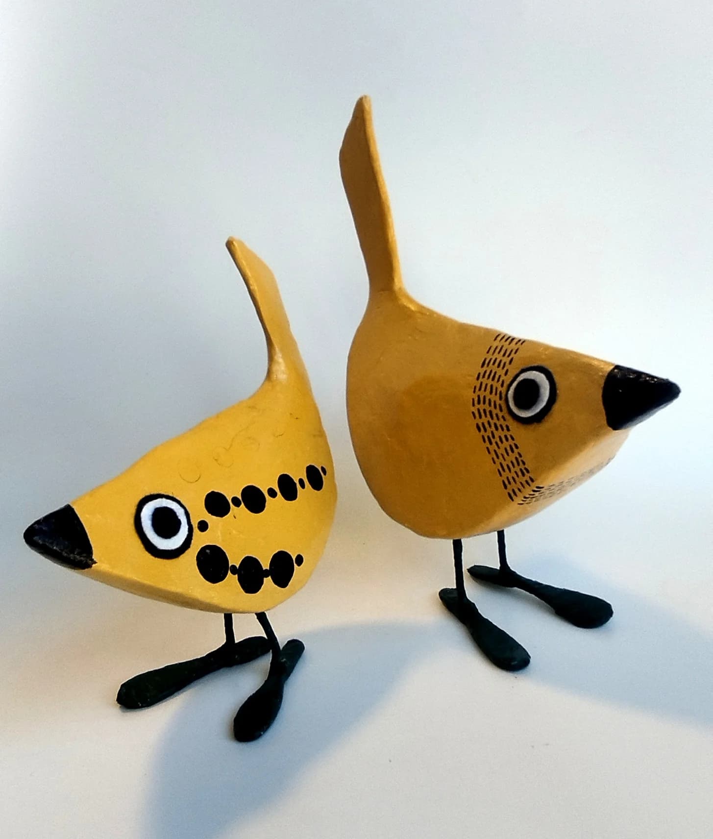 A pair of curious, ochre-colored birds
